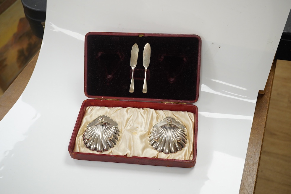 A cased pair of late Victorian silver butter shells with matching butter knives, Horace Woodward & Co Ltd, London, 1897, 95mm. Condition - good